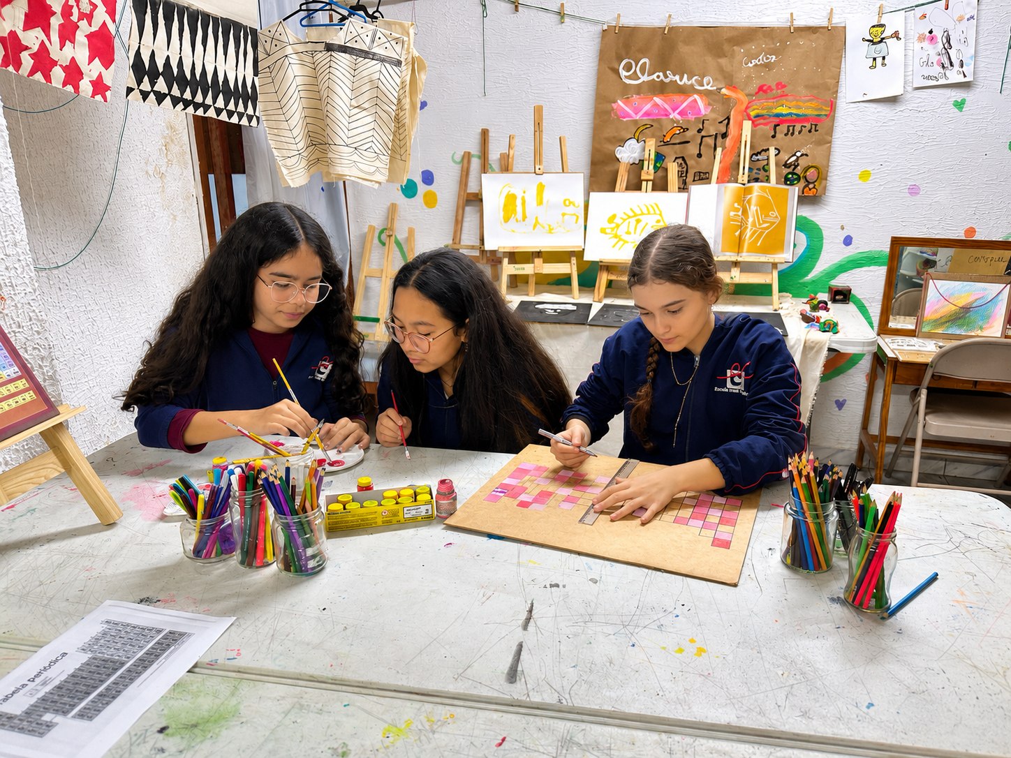 Alunas pintando e desenhando na sala de artes